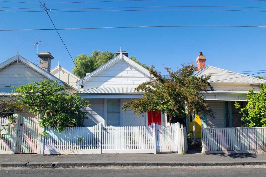 Row of quaint terrace houses with white picket fences