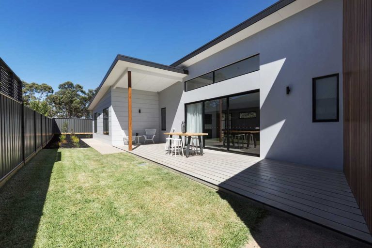 Modern home with deck and backyard lawn