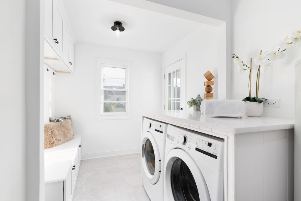 Bright white laundry with washer, dryer and storage