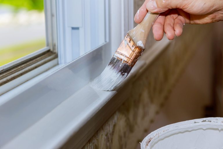 Hand painting white window sill with brush
