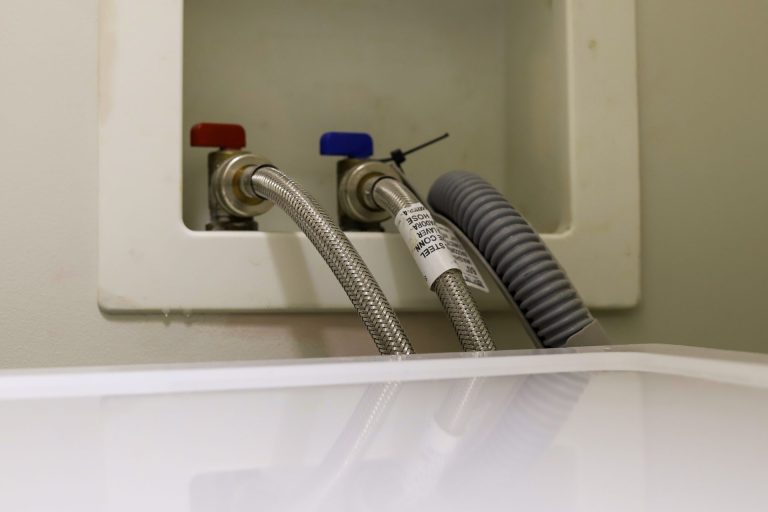 Washing machine hoses connected to hot and cold taps