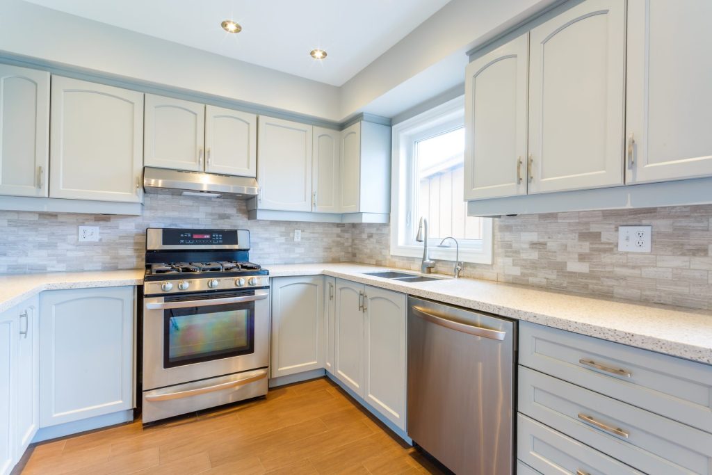 Modern kitchen with stainless steel appliances and light cabinets