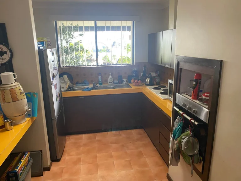 Compact kitchen with yellow benchtops and window