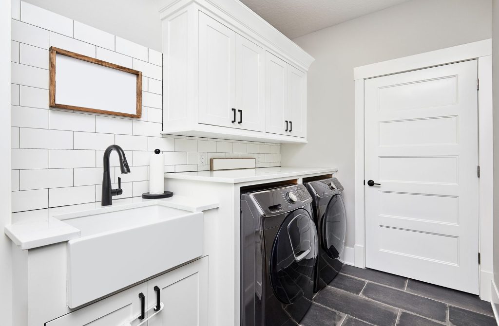 Modern laundry with farmhouse sink and front loaders