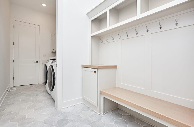 Modern mudroom with bench and adjacent laundry