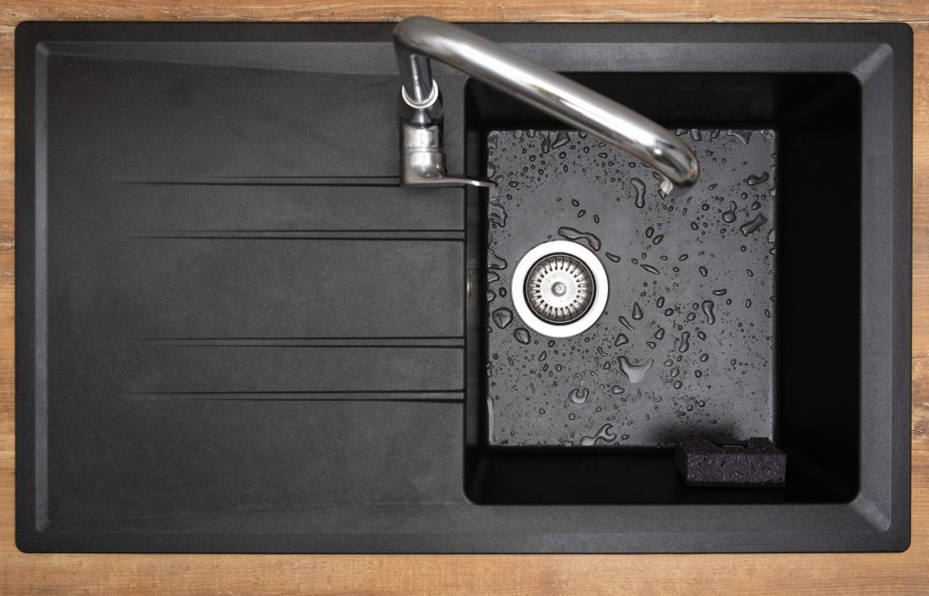 Top view of black kitchen sink and tap