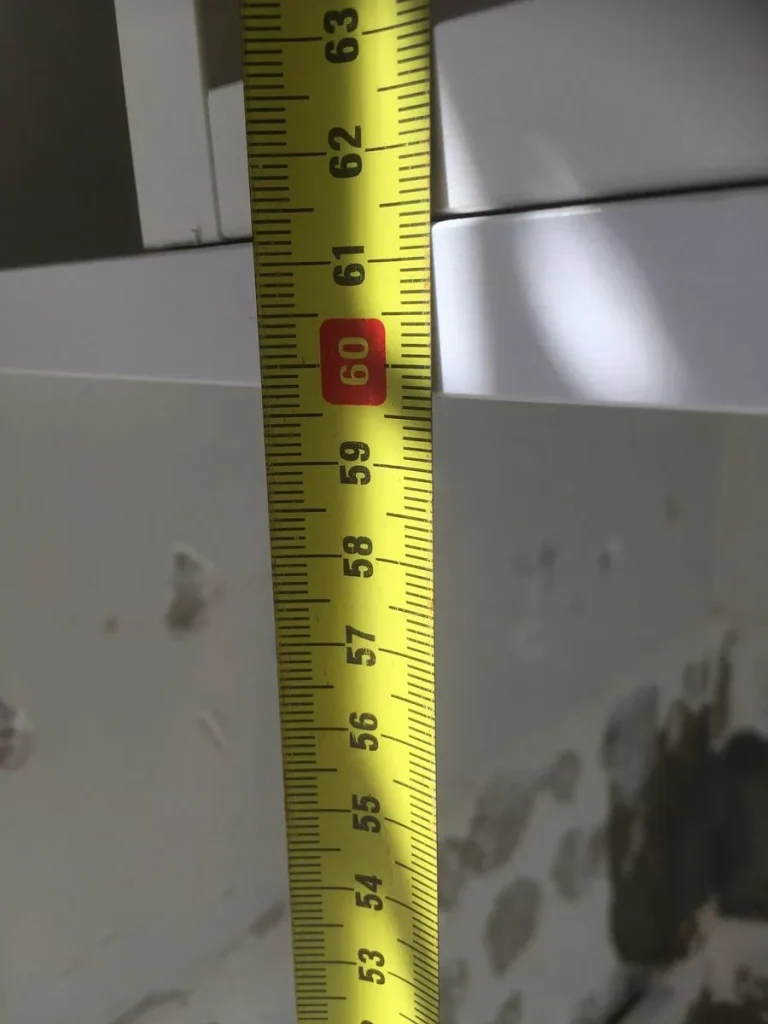 Tape measure showing 60 centimetres against wall