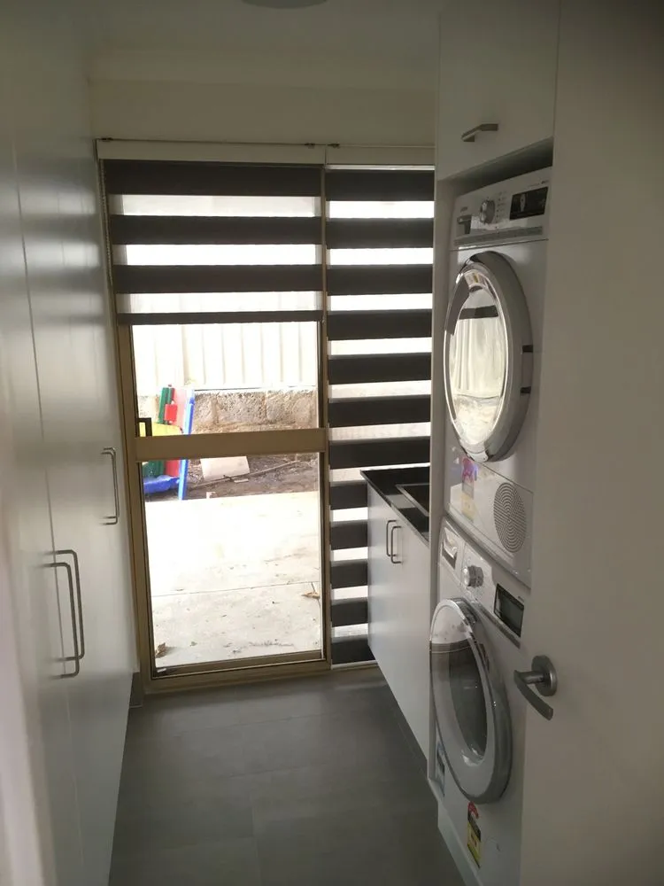 Compact laundry with stacked washer, dryer and sliding door