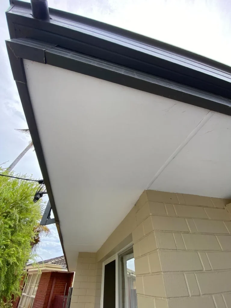 House eaves and guttering above brick wall